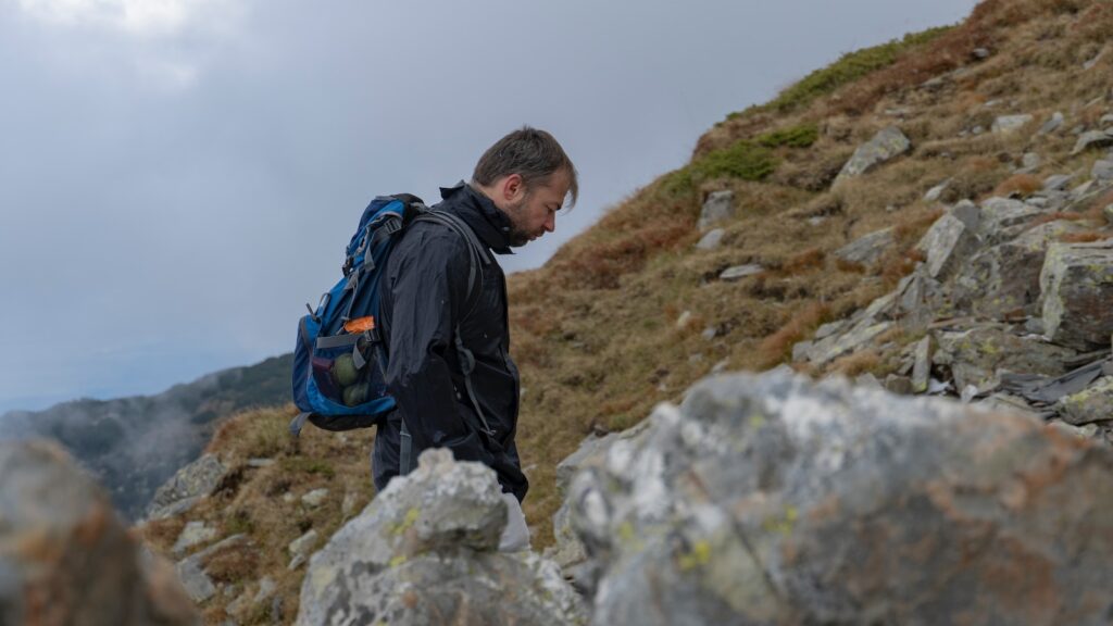a man with a backpack on a rocky hill